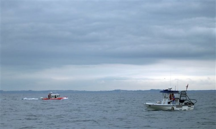 Members of The United States Coast Guard, left, and the Mason County Sheriff's office, right, search the waters of Lake Michigan after a medical transport plane carrying five people to the Mayo Clinic crashed into the lake on Friday.